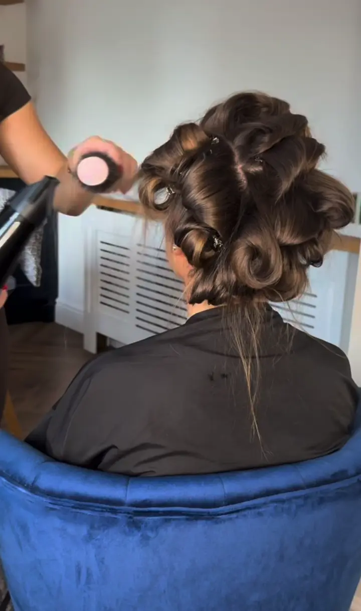 Brunette hair set in rollers, then brushed out into bouncy curls