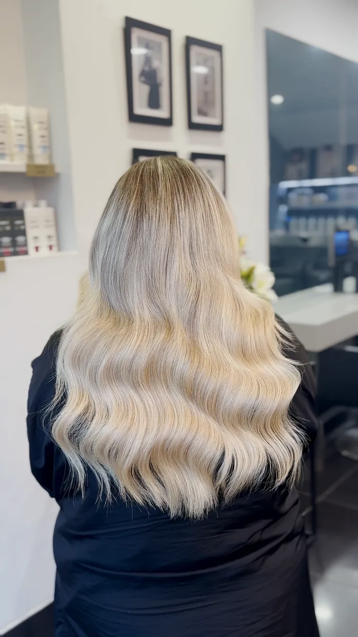 Long icy blonde hair with a seamless weft, finished in soft waves